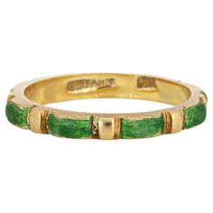 Vintage Tiffany & Co green enamel ring crafted in 18 karat yellow gold (circa 1970s to 1980s). Green enameled panels are continuous around the band for a seamless look. The enamel is in fair condition with enamel loss present. The slim 2.5mm wide band (0.09 inches) is great worn alone or stacked with your fine jewelry from any era. The ring is in fair condition. We have not cleaned it in order to preserve the patina and collector value. Particulars: Weight: 2.8 grams Stones: N/A Size & Measurements: The ring is a size 5 (not sizable). The band measures 2.5mm wide (0.09 inches), rising 3mm from the finger. Metal & Hallmark: 18 yellow gold. The ring is hallmarked "18k" and "Tiffany" Tiffany Co Rings, Vintage Tiffany, Stacking Bands, Ring Crafts, Enamel Ring, Wide Band Rings, Tiffany And Co, Green Enamel, Wide Bands