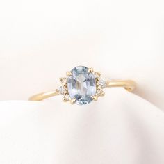 a ring with an oval cut blue topazte surrounded by smaller round white diamonds