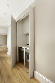 an open door leading to a washer and dryer in a room with hard wood floors