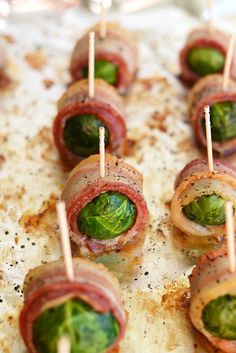 small appetizers are wrapped in bacon and lettuce on toothpicks