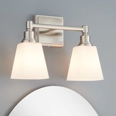 two light bathroom fixture with frosted glass shades on the top and bottom lights in brushed steel finish