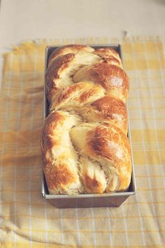 a loaf of bread sitting on top of a yellow and white checkered table cloth