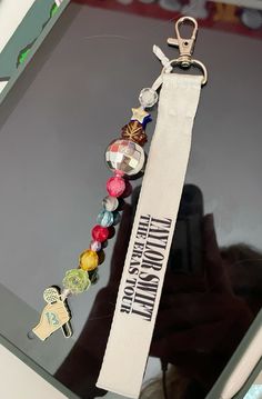 a white lanyard with some charms attached to it's side on a computer screen