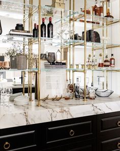 a marble counter top topped with shelves filled with bottles