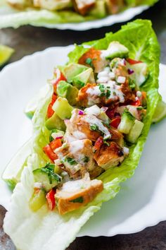 two lettuce wraps with chicken and vegetables on them