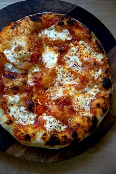 a pizza sitting on top of a wooden cutting board