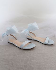 a pair of white shoes with bows on them