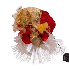 a red and white flower with gold sequins on it next to a charger