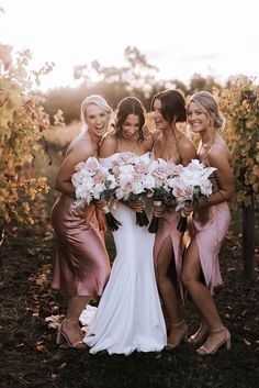 the bridesmaids are all dressed in pink dresses and holding their bouquets together