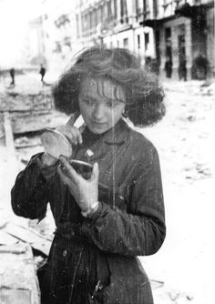 an old black and white photo of a woman holding a cell phone in her hand