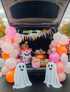 the trunk of a car with balloons, candy and decorations in it is decorated for halloween