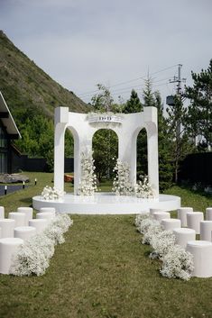 an outdoor ceremony setup with white flowers and candles