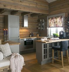 a kitchen and living room with wooden walls