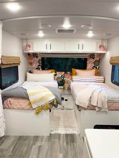 the inside of a camper with two beds and pillows on it's sides