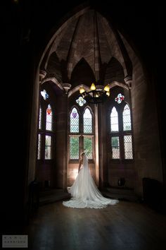 the bride is standing in front of two stained glass windows