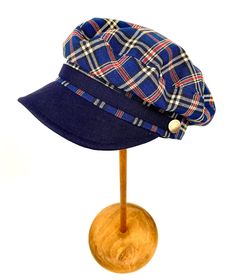 Classic and elegant blue tartan plaid sailor cap. Adorned with a ribbon of the same fabric as the visor and riveted with metallic buttons in old silver color. 65 % polyester 35% linen. Cut and sewn on the bias with a quality tartan plaid fabric and finished with a very light cotton lining. The length of the visor is 4.5 centimeters. The back of the cap has a small eco-leather belt to adjust the measurement up to three centimeters less. It adapts very well to the head. For its production we use t Navy Visor Hat For Summer, Navy Cotton Brimmed Hat, Casual Navy Brimmed Bucket Hat, Navy Adjustable Baseball Cap For Summer, Blue Casual Visor Sun Hat, Navy Bucket Hat With Curved Brim For Summer, Navy Short Brim Summer Hat, Blue Visor Hat - One Size Fits Most, Adjustable Navy Baseball Cap For Beach