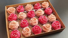 a box filled with pink and red cupcakes on top of a black table