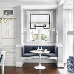 a dining room with white walls and wood flooring, along with two blue chairs