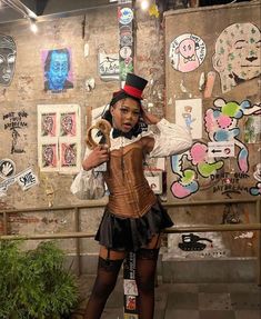 a woman dressed up as a steampunk in front of a wall with stickers on it