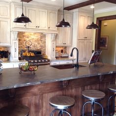 a kitchen with an island and stools next to the counter top in front of it