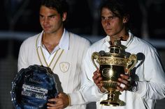 two tennis players holding trophies and posing for the camera