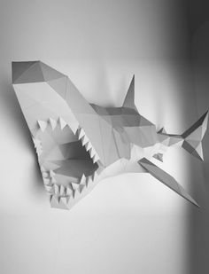 an origami shark with its mouth open and sharp teeth hanging from the wall