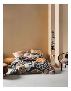 a bed sitting in a bedroom next to a chair and book shelf on top of a wall