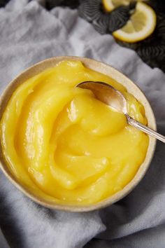 a spoon in a bowl filled with lemon custard