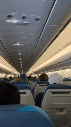 the inside of an airplane with people sitting on seats