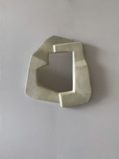 a white wall mounted object with a square shaped hole in it's center on the wall