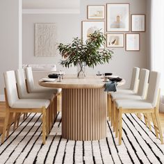 a dining room table with white chairs and a plant in a vase on top of it