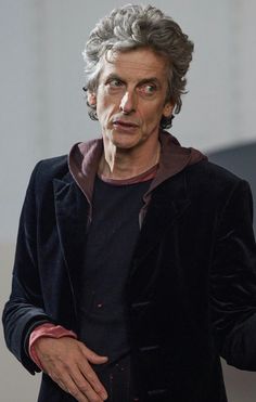 doctor who is holding his hand out and looking at something in the distance with one eye open