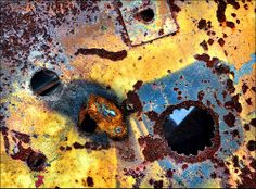 an old rusted metal surface with holes and rivets