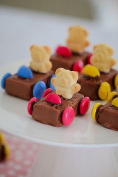 there are many small pieces of chocolate with teddy bears on it and in the shape of cars