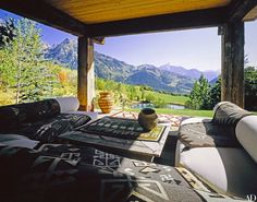 an outdoor living area with mountains in the backgroud and furniture on the patio