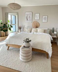 a bedroom with a bed, rugs and pictures on the wall above it is shown