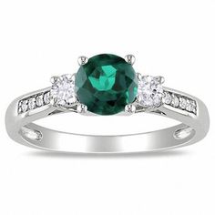 Radiant with color and contrast, this ring will dazzle and delight any woman. Fashioned in 10K white gold, this ring features a brilliant 6.0mm lab-created bright green emerald center stone. Smaller lab-created white sapphires flank this regal gemstone, while shimmering diamond accents adorn the ring's shank. Polished to a brilliant shine, this ring is certain to become a treasured favorite. Gems Rings, Large Gold Ring, Pink Sapphire Band, Diamond Alternative Engagement Ring, Diamond Accent Ring, Real Gold Jewelry, Three Stone Engagement Ring, Lab Created Emerald, Fine Diamond Jewelry