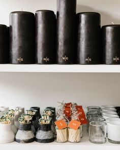 candles are lined up on shelves in a store