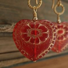 "Beautiful red glass hearts, etched in gold, hang from delicate, twisted wire loops and decorative earwires of vermeil. A lovely gift for yourself or somebody else on Valentine's Day. Length from bottom loop of earwire: 1\"(25mm) Diameter of heart: 3/4\"(20mm) All Debra Dane jewelry arrives in a pretty box suitable for gifting. These earrings are also available with non-pierced gold plated clips. They will have a gold ball instead of the ornate piece that is on the pierced earwires." Handmade Festive Jewelry For Valentine's Day, Red Heart Charm Earrings As Gift, Red Heart Charm Earrings For Gift, Handmade Red Heart Earrings For Anniversary, Valentine's Day Festive Heart-shaped Jewelry, Heart Pendant Earrings With Beads For Gift, Heart Pendant Earrings With Heart Beads, Festive Heart Jewelry With Heart Beads, Gold Double Heart Handmade Earrings