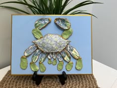 This beautiful crab picture is made using a real crab shell which has been cleaned, sanitized, hand painted and decoupaged.  Various other shells are used for the claws and legs using the same process.  All shells are gilded on the edges with gold paint.  It is mounted on a hand painted 9x12" canvas with a hand painted gold border.  It makes a perfect gift for a beach/crab lover in your life or beautiful coastal decor in your own home. Each shell is one of a kind and no two are exactly alike.  The crab shells are approximately 5-7.5 inches point to point.  These are handmade to order and processing takes 3-5 days.  The description and photos are used to create a general visual portrait of the item. Crab Picture, Beach Jar, Beachy Crafts, Tropical Interiors, Pawleys Island Sc, Crafting Business, Oyster Shell Crafts, Crab Shells, Coastal Christmas Decor