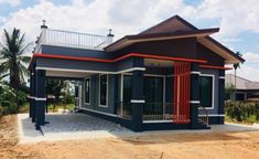 a blue house with red trim on the roof