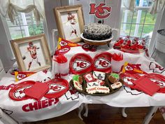 a table set up for a football party with plates, cookies and cupcakes