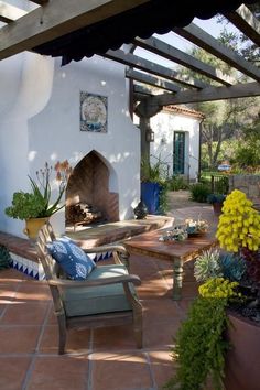 an outdoor patio with chairs, table and fireplace