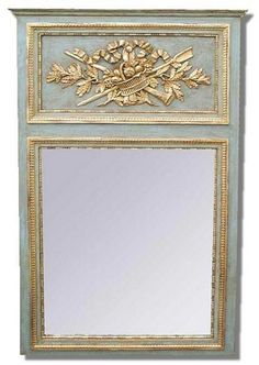 a mirror that is sitting on top of a shelf with leaves and flowers painted on it