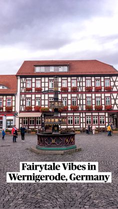 people are walking around in front of a building with a clock on it's pedestal