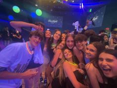 a group of young people standing next to each other in front of a disco ball