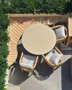 an overhead view of a table and chairs on a patio with plants growing around it