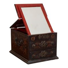 an old wooden box with a mirror on it's lid and drawers in the middle