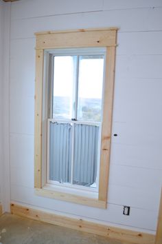 an empty room with a window and no curtains on the windowsill, in front of a white painted wall