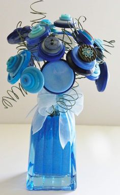 a blue vase filled with lots of buttons